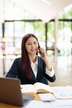 Asian businesswoman using the phone to contact a business partner
