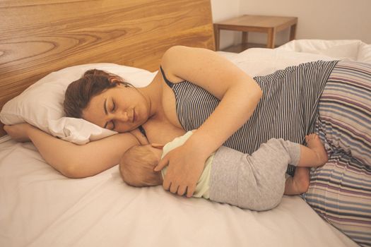 Mother and newborn baby sleep in the bed