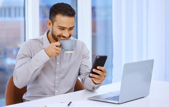 I knew technology would simplify things for me. a young businessman using his cellphone and drinking coffee while sitting at his desk.