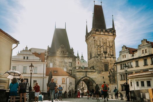Prague, Czech Republic - July 2022. People tourists are walking on famous medieval Charles - Karlov bridge across Vltava river. Historic, old district of european capital