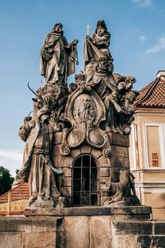 Prague, Czech Republic - July 2022. Prague Turk Statues of John of Matha on famous medieval Charles Bridge - Karlov bridge across Vltava river. Historic, old district of european capital