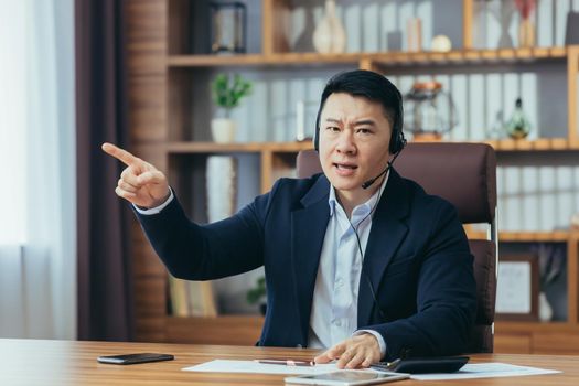 Online conference, Asian boss with headset informs employee about dismissal