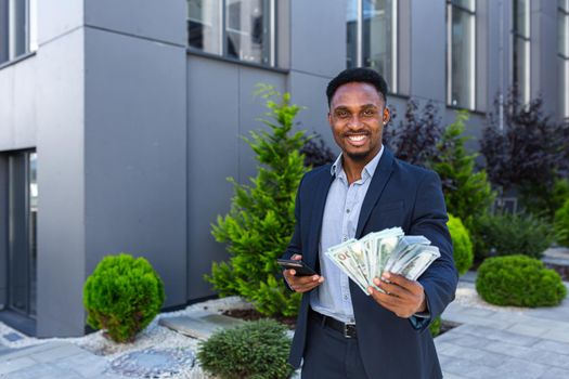 African american businessman standing on street modern building show earnings winning