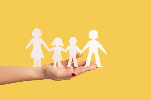 Woman hand holding paper family chain, relationships between children and parents.