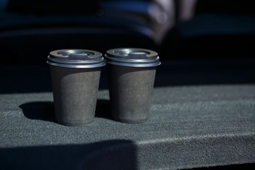 Black eco paper cups for taking coffee with you. Two cups of hot tea with a lid