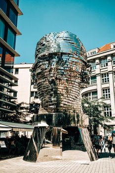Prague, Czech Republic - July 2022. Moving mirror statue of Franz Kafka by David Cerny. Big metalmorphosis head sculpture.