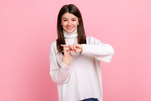 Positive popular woman blogger making hashtag sign with fingers, tagging posts in social networks.
