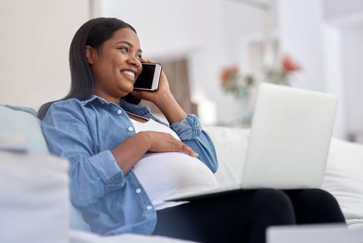 What I love about being pregnant Everyone calling to check up on me. a pregnant woman talking on her cellphone while sitting with her laptop.