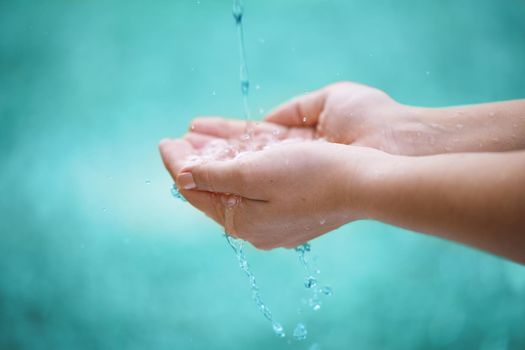Save water. water flowing onto the hands of an unrecognizable person.