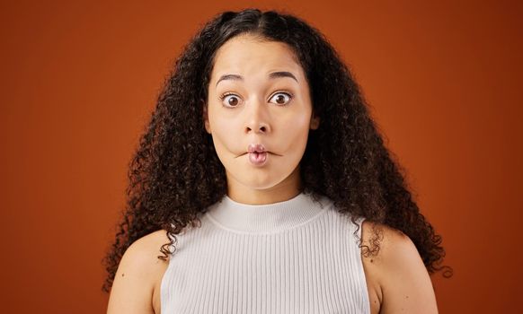Im not saying anything. Cropped portrait of an attractive young woman making a face in studio against a red background.