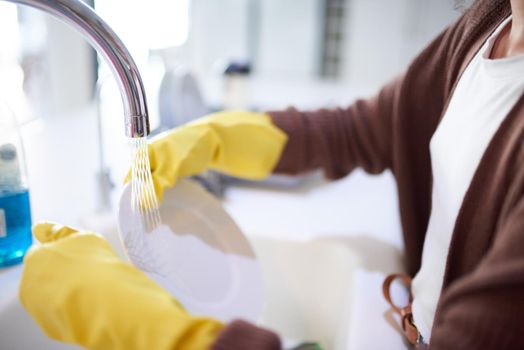 No one likes a dirty kitchen. an unrecognizable woman washing the dishes at home.