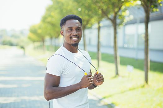 Young fitness trainer holding a skipping rope looking at the camera