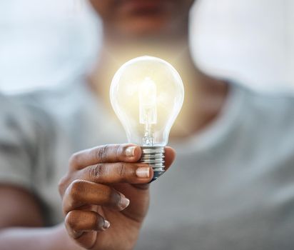 Use your knowledge to bring light to this world. an unrecognisable businesswoman holding a lightbulb.