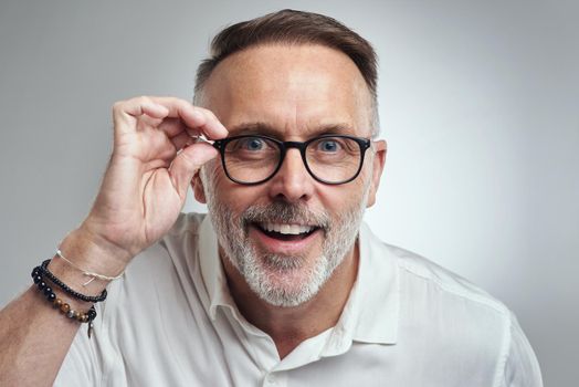 Seeing is believing. Studio portrait of a mature man wearing spectacles against a grey background.