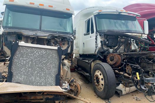 Two trucks after accident crashed, disposal of the car, cargo van broken in a road crash, destroyed lorry after a head-on collision in junkyard.