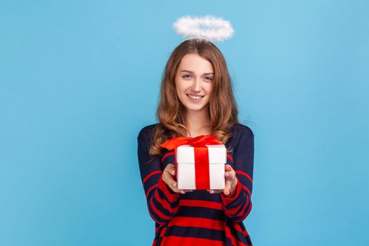 Woman with nimb over head, holding out wrapped present box, congratulating with holiday.