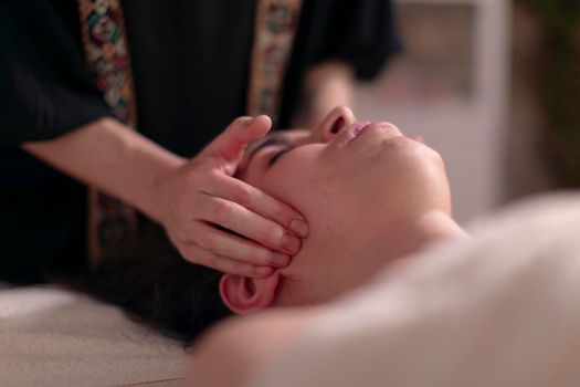 A masseuse massages the jaws of her patient