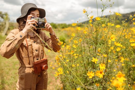 Female tourist taking photo of beautiful flowers in Africa national park