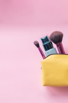 Top view of set of make up and skin care products spilling out of cosmetics bag on pink background. Beauty concept.Taking care of the body and skin quality.Various cosmetic products