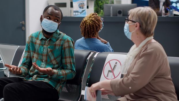 African american patient talking to senior woman with face masks