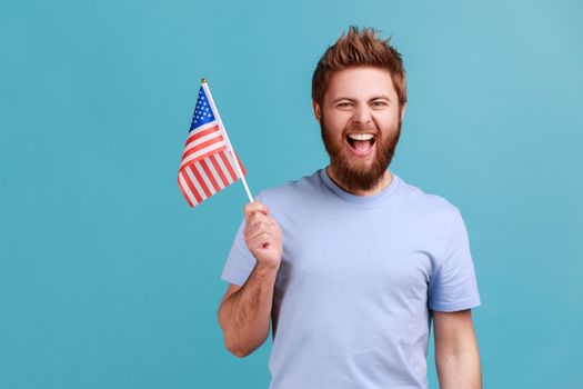 Man holding in hand flag of united states of america celebrating independence day excited expression