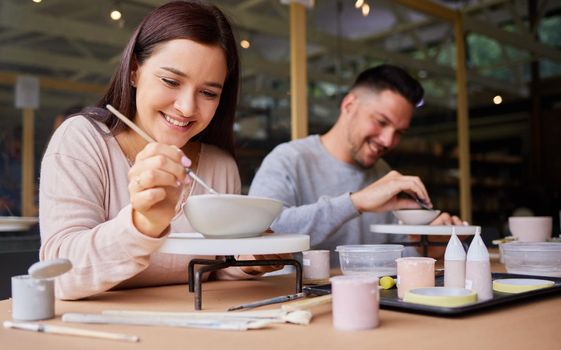 I never had this much fun on a date. a young couple painting ceramics in an art studio.