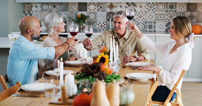 Friends like you are special everyday of the year. two happy couples sitting down for lunch and toasting with wine glasses at home.