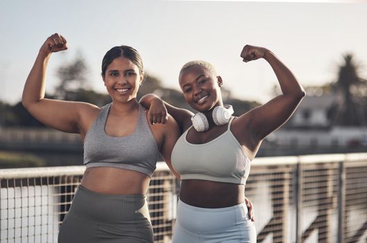 What doesnt kill you makes you stronger. two young women flexing while out for a run.