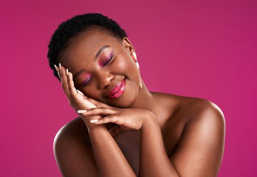 A smile a day keeps the sadness away. Studio shot of a beautiful young woman posing against a pink background.