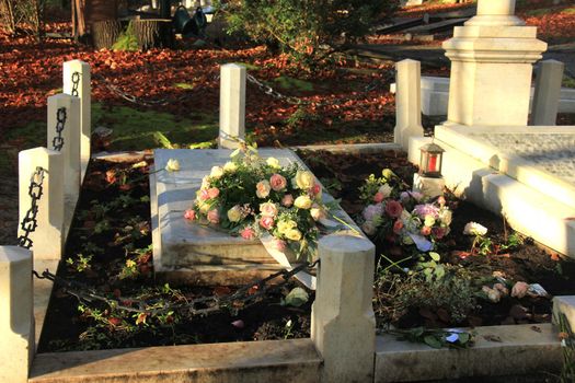 White and pink funeral flowers on a marble tomb