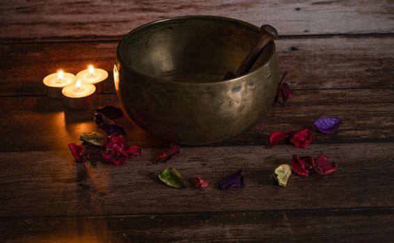 tibetan bowl with flower petals and candles