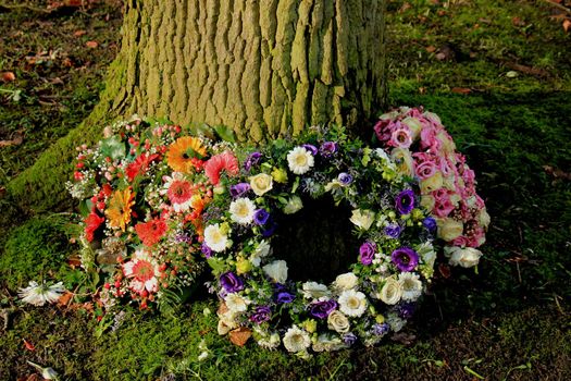 Sympathy wreath or funeral flowers near a tree