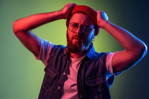 Hipster man in glasses, looking at camera, raised arms, expressing pensive dreamy emotions.