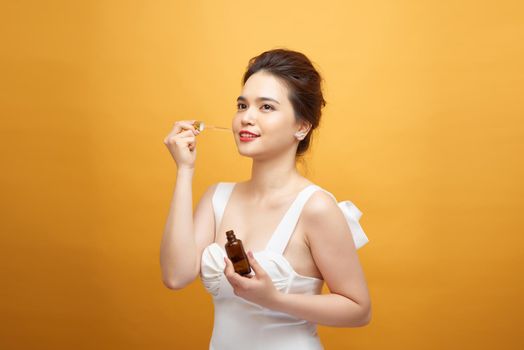 young beautiful asia woman uses serum for face. The concept of facial skin care
