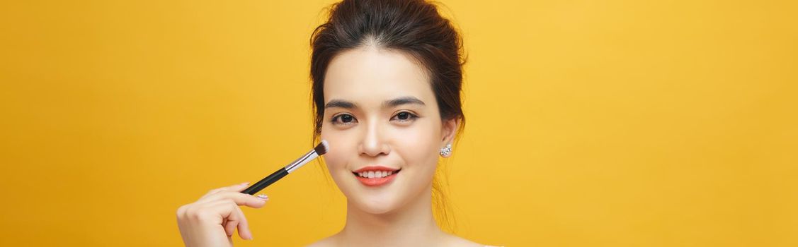 Woman applying make up with brush, isolated. Beauty procedures