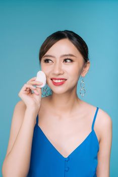 Woman using cotton pad. Happy smiling beautiful young woman cleaning skin by cotton pad.