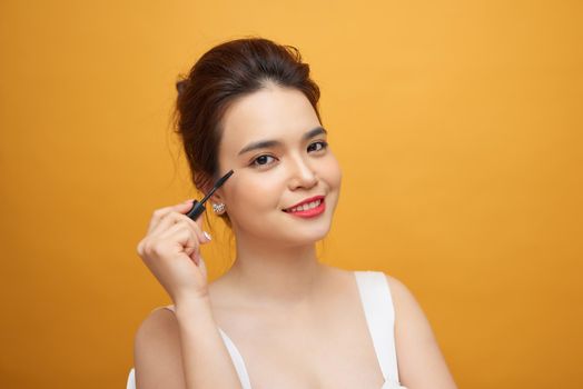 Woman mascara applying brush, female portrait makeup eyelashes.