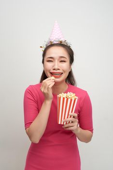 Young asian woman desperate and sad. She is holding a popcorns bucket.