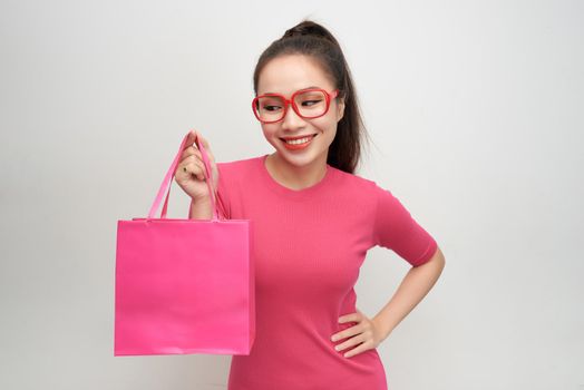 Joyful woman shopping packages pink color