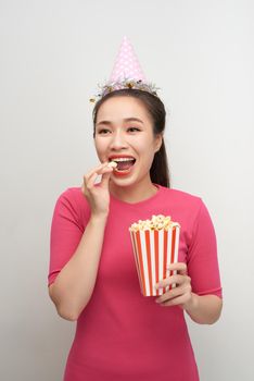 Portrait of a laughing woman holding popcorn isolated over white background