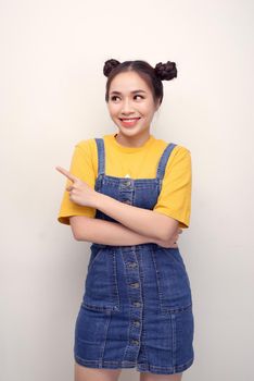Close up photo beautiful amazing she her lady buns show indicate direct index finger empty space new product wear casual t-shirt jeans denim overalls clothes isolated white background