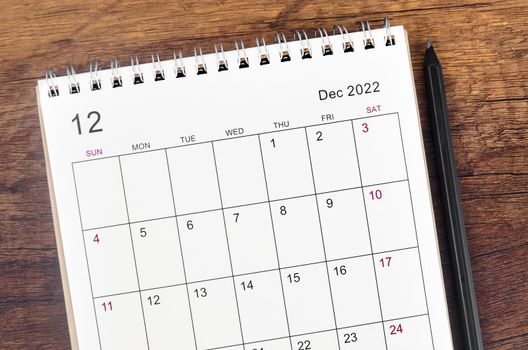 The December 2022 desk calendar on wooden table.