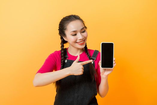 Pretty asian woman holding smartphone and pointing finger to the smartphone. 
