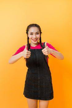 Portrait of Asian woman pointing at something on color background