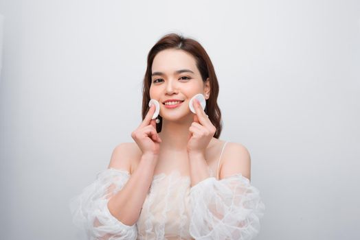 Beautiful young smiling woman with clean cotton pads . Facial treatment. Beauty skin care famale face . Expressive facial expressions.