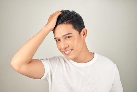 Portrait of happy healthy man combing his hair with fingers