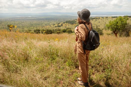 Young woman with backpack enjoying the views of the savannah