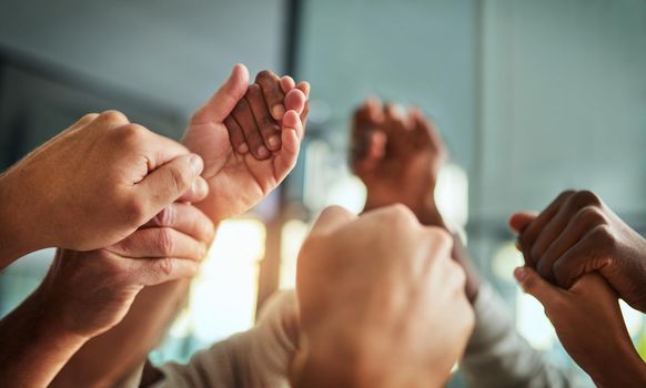 Diverse people holding hands in teamwork, success and support while showing solidarity, trust and unity in office. Closeup of business team, men and women standing together for equal workplace rights