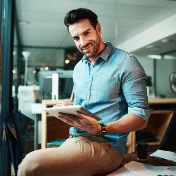 Confident businessman with tablet holding, browsing and searching online while working overtime on startup company. Portrait of smiling, happy and successful creative finishing deadline on technology
