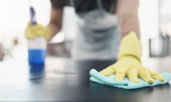 Keep it clean, keep it safe. an unrecognisable woman disinfecting a table at home.